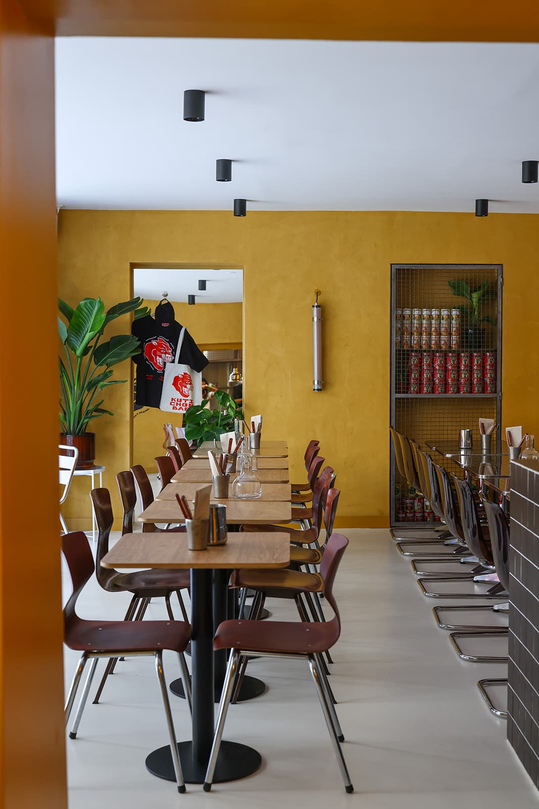 Intérieur de KUTI : murs ocre, mobilier dépareillé et cave à conserves